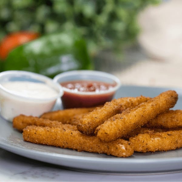 Golden-brown mozzarella sticks on a gray plate with small cups of marinara and ranch dipping sauces.