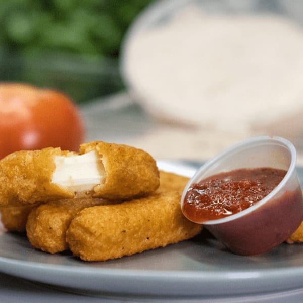 Golden-brown mozzarella sticks, one broken open to show melted cheese, with a side of marinara sauce.
